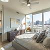 bedroom with ceiling fan and view of city