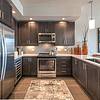 kitchen with stainless steel appliances, dark wood cabinets and pendant lights