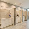 cream colored shower stalls and tile floors and metal tables for pet grooming