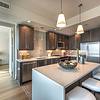 Kitchen with stainless steel appliances and island with seating and pendant lighting