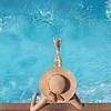 Top view of woman in straw hat relaxing in pool
