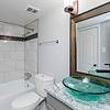 green glass basin sink and large framed mirror