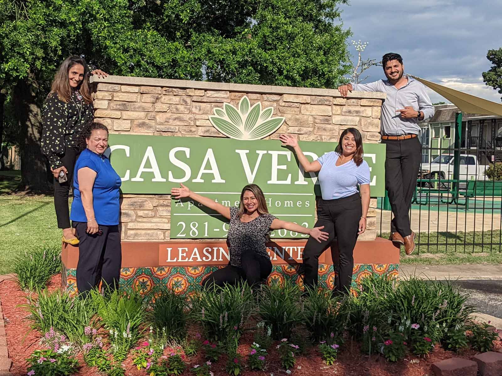 five people standing around a sign for Casa Verde apartments
