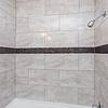 shower at Allendale with a decorative band of darker tiles