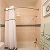 shower with a curved rod and white curtain