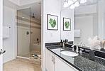 Bathroom with white cabinetry and shower and tub combination