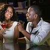 Couple talking and smiling while having drinks at bar counter in bar
