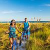 Young woman and man riding bicycles on beach