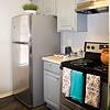 stainless steel refrigerator in a kitchen with gray cabinets