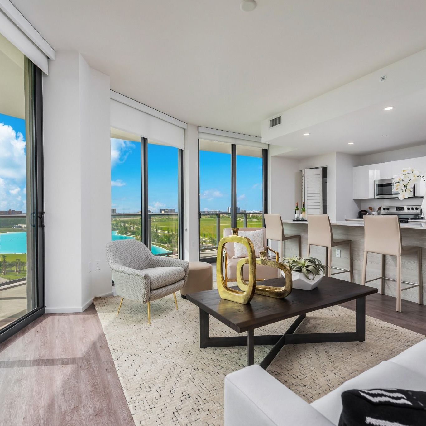 Apartment living room with coffee table, couch, sliding glass door to balcony and entertainment center