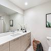Spa-like bathrooms Apartment bathroom with dual vanity, toilet, towel basket, art work on the wall and decorations on the countertop at Solé Mia Rentals in North Miami, Florida