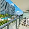 Private Balconies Apartment balcony with patio furniture overlooking pool at Solé Mia Rentals in North Miami, Florida