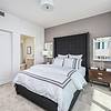 Stylish Interiors Apartment bedroom with bed, closet, and end tables at Solé Mia Rentals in North Miami, Florida