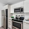 Stainless Steel Appliances Kitchen area with appliances, white cabinets, and cooking utensils at Solé Mia Rentals in North Miami, Florida
