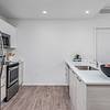 Modern Open Kitchens Kitchen area with appliances, center island, and bowl of fruit at Solé Mia Rentals in North Miami, Florida