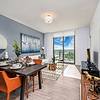 Stylish Interiors Apartment dining area with artwork on the walls, mirror, and glass door to the exterior at Solé Mia Rentals in North Miami, Florida