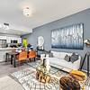 Spacious Layouts Apartment living area with area rug, couch, chair, dining area, lamps and wall hangings at Solé Mia Rentals in North Miami, Florida