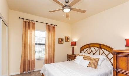 Furnished bedroom with window and ceiling fan
